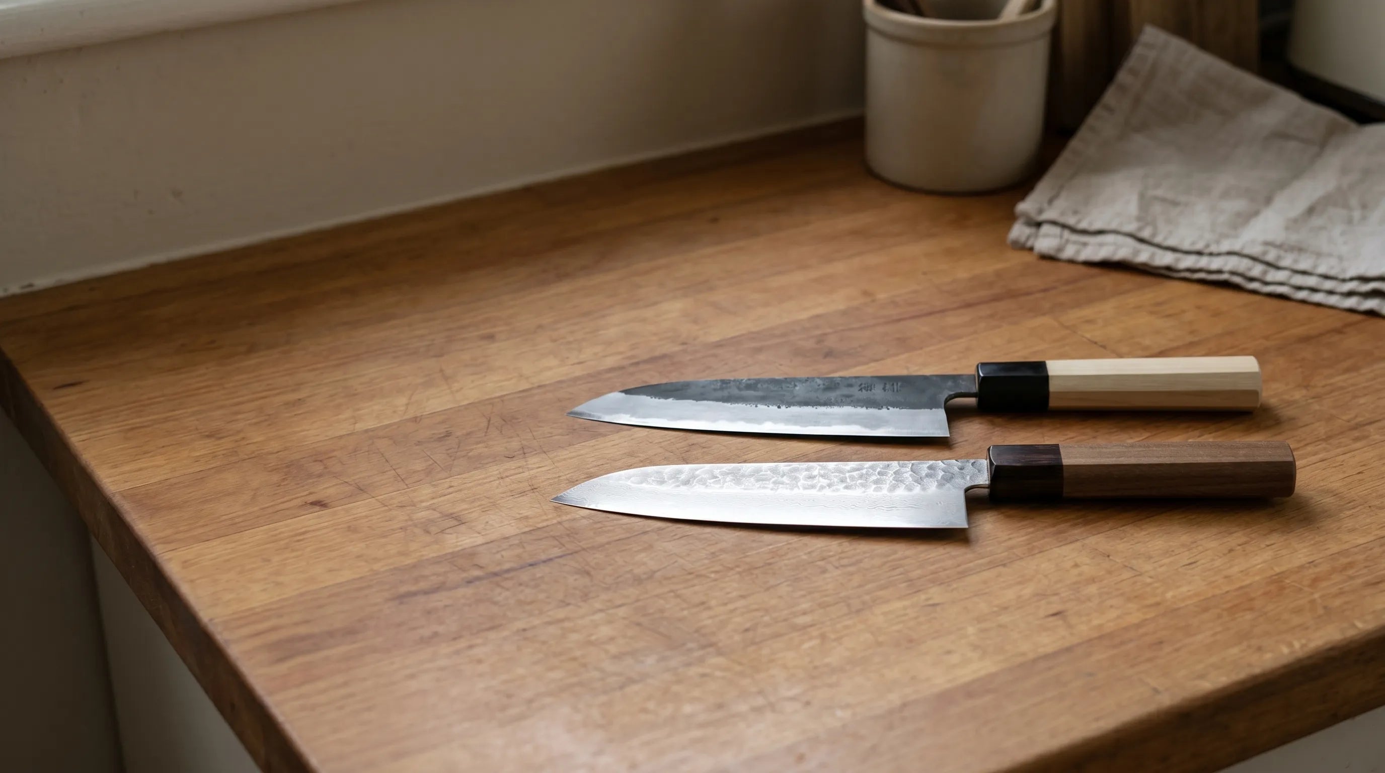 Photo of a Yoshimi Kato santoku knife showing the black kurouchi finish and red pakkawood handle